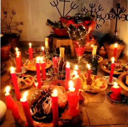 Oferenda com velas vermelhas e alimentos em um altar