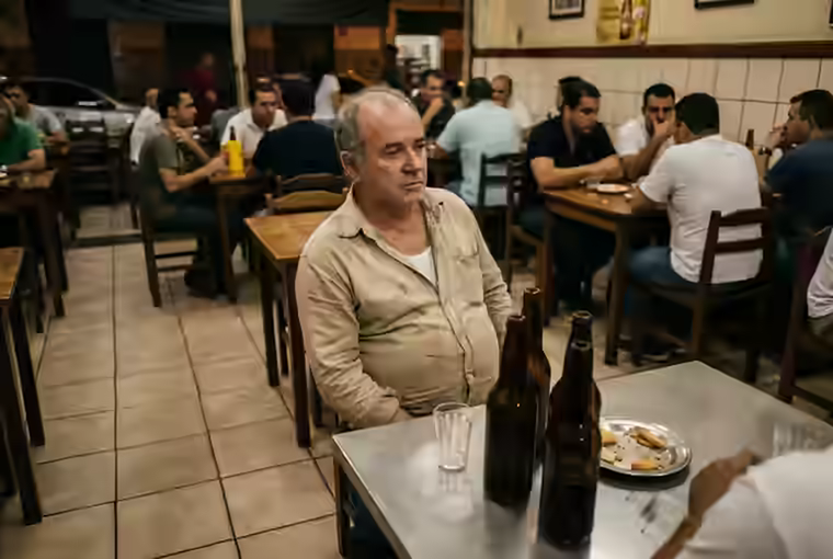 Simpatia para parar de beber, homem bebendo sozinho num boteco